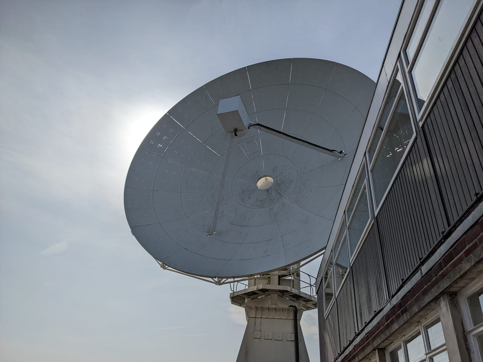 The silver dish of the 42-foot telescope stands beside the windowed control building.