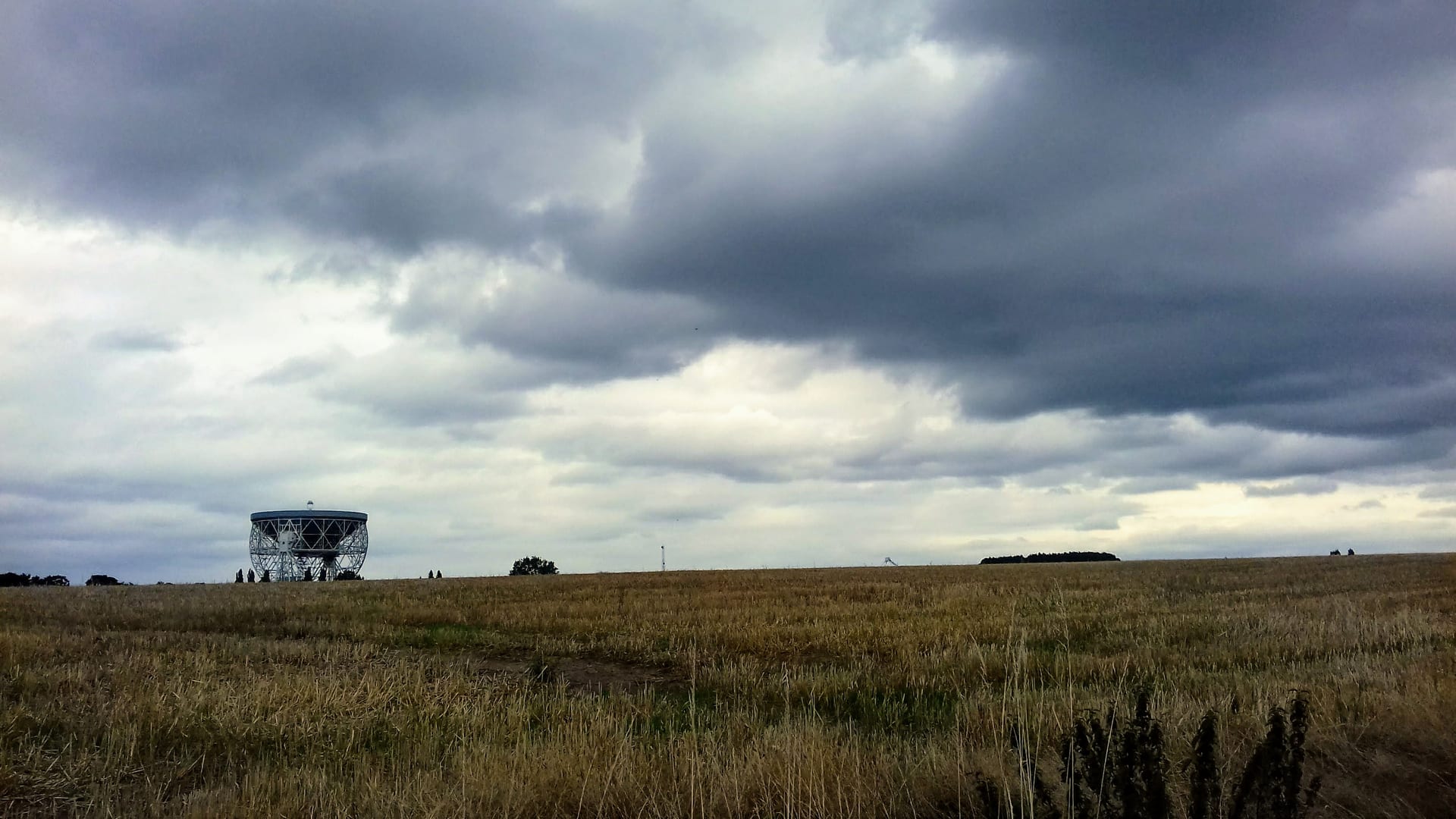 The white dish of the Lovell Telescope rises above fields near Jodrell Bank.